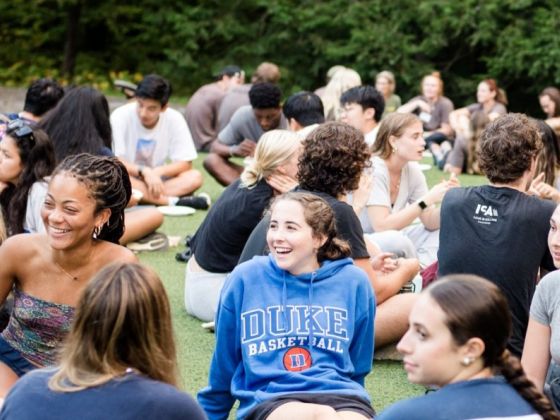 students gathered around sitting on the grass